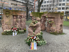 Foto des Block der Frauen nach einer Gedenkveranstaltung. Die Statuen sind mit weißen Rosen und Gedenkkränzen geschmückt.