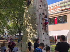 Foto des Kletterturms beim Sommerfriedensfest der Linksfraktion Berlin Mitte im Ottokar. Ein Kind klettert, es hat sich eine Schlange gebildet.