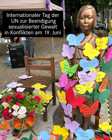 Foto der Friedensstatue in Berlin-Moabit. An die bronzene Statue der jungen Frau sind zahlreiche Schmetterlinge mit Forderungen und Wünschen in vielen verschiedenen Sprachen geheftet. In einer Textbox steht „Internationaler Tag der UN zur Beendigung sexualisierter Gewalt in Konflikten.“