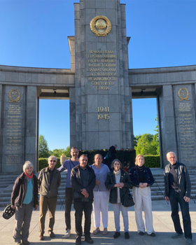 Gruppenfoto: Eine Gruppe Menschen steht in Andacht vor dem Sowjetischen Ehrenmal im Tiergarten.