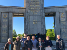 Gruppenfoto: Eine Gruppe Menschen steht in Andacht vor dem Sowjetischen Ehrenmal im Tiergarten.